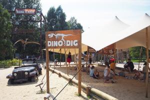 Kinderen zijn bij de Fossil Dig bij Dinoland druk bezig met het uitgraven van een enorm T-Rex skelet.